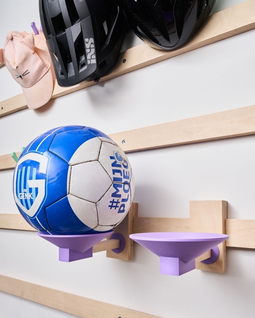 Voetbal in een houder van het WandOrde wandsysteem